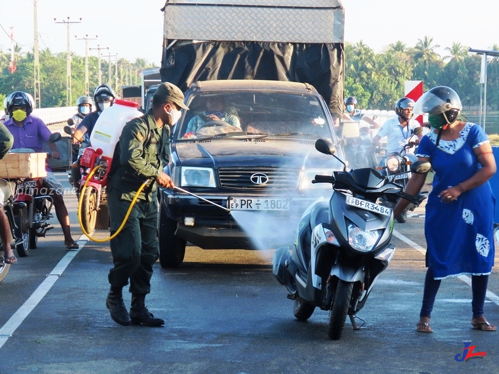 கொரோனா வைரஸ் கிருமி அழிப்பு மருந்து இராணுவ சோதனை சாவடியில் விசுறப்படும் காட்சி